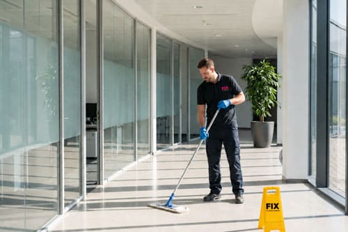 Mitarbeiter bei der Bodenreinigung in einem modernen Gewerbegebäude